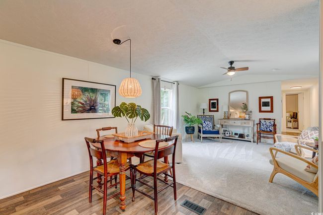 Dining space featuring wood finished floors, vaulted ceiling, ceiling fan, and a textured ceiling | Image 8