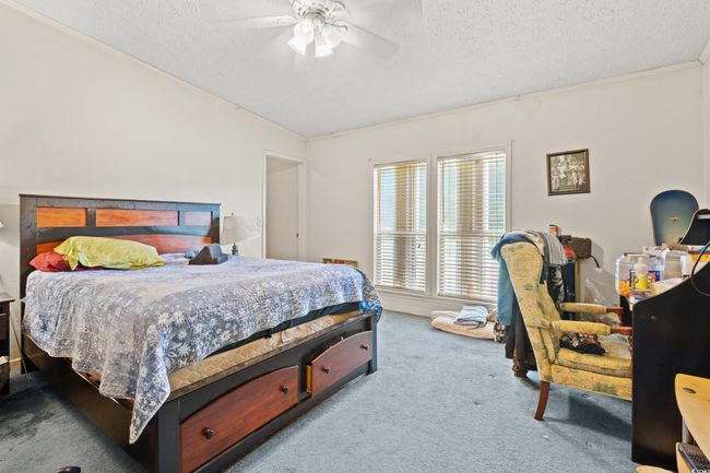 Carpeted bedroom featuring a textured ceiling, ceiling fan, and vaulted​​‌​​​​‌​​‌‌​‌‌​​​‌‌​​‌‌​‌​​​​​‌ ceiling | Image 24