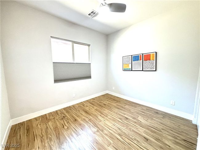 Unfurnished room with wood finished floors, visible vents, ceiling fan, and baseboards | Image 31