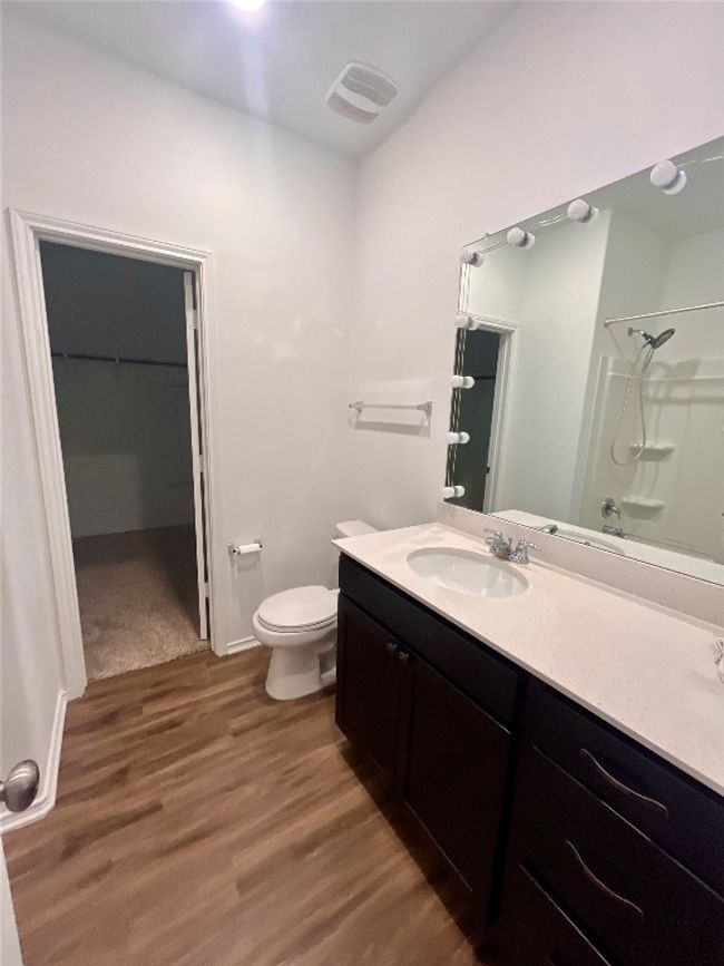 Bathroom with a shower, vanity, wood finished floors, and a walk in closet | Image 8