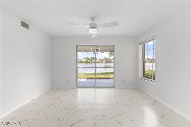 Tiled spare room featuring a water view and ceiling fan | Image 43
