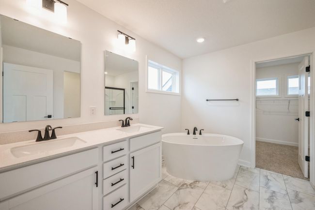 Photo is of the actual home. The primary bath includes a double-vanity, a soaking tub and a separate shower. | Image 10