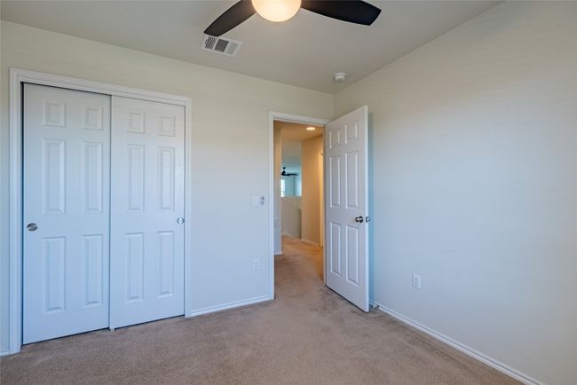 Unfurnished bedroom featuring light colored carpet, a closet, and a ceiling fan | Image 18