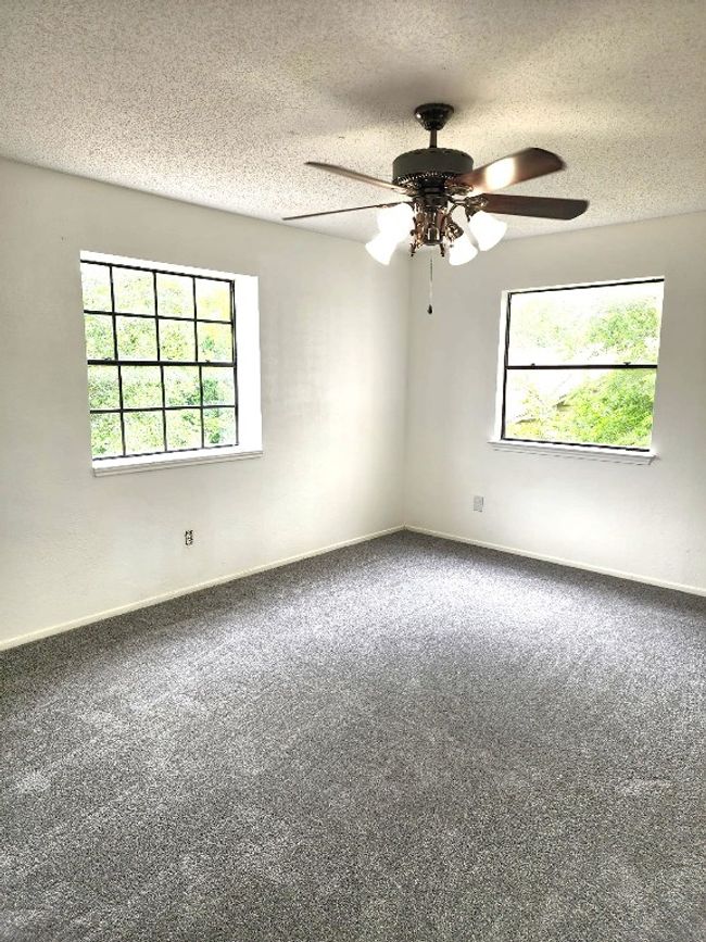 Empty room with plenty of natural light, carpet, a ceiling fan, and a textured ceiling | Image 6
