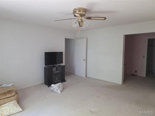 Unfurnished living room featuring ceiling fan and carpet | Image 8