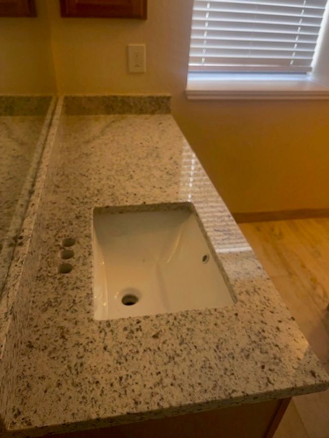New light fixture, faucet, and granite counter with make up desk. | Image 22