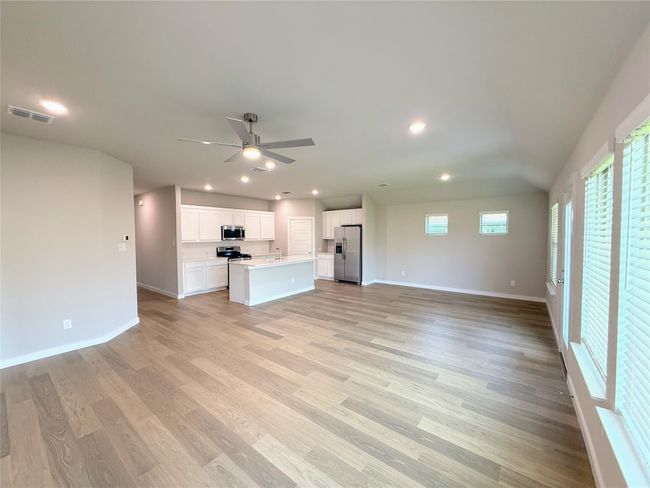 Unfurnished living room featuring ceiling fan, light wood finished floors, and recessed lighting | Image 11