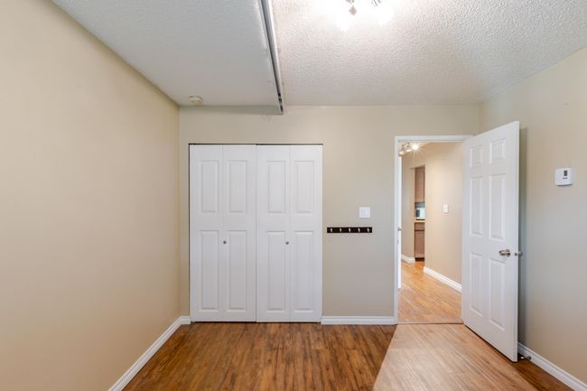 Unfurnished bedroom with baseboards, wood finished floors, and a closet | Image 24