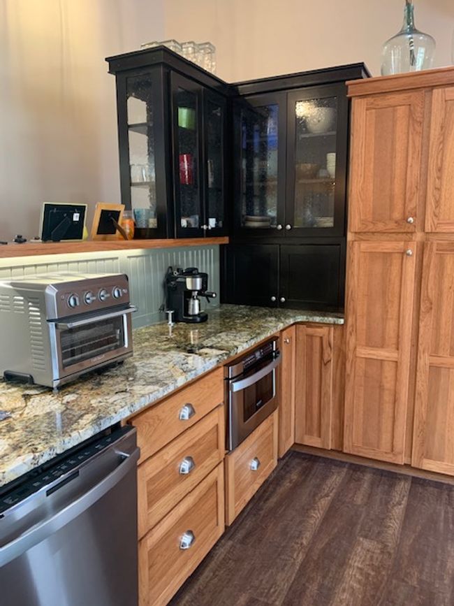 Kitchen featuring a toaster, dishwasher, wall oven, dark wood finished floors, and glass insert cabinets | Image 17