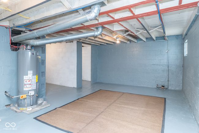 unfinished below grade area with concrete block wall and water heater | Image 26