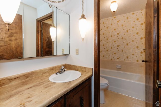 Full bath with vanity, shower / bathtub combination, and wallpapered walls | Image 16