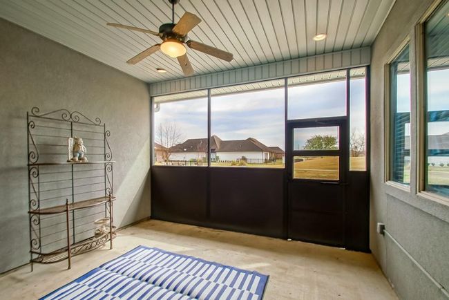Partially screened in porch with recessed lighting, fan/light, electrical outlets, & back door leads to another patio. | Image 28