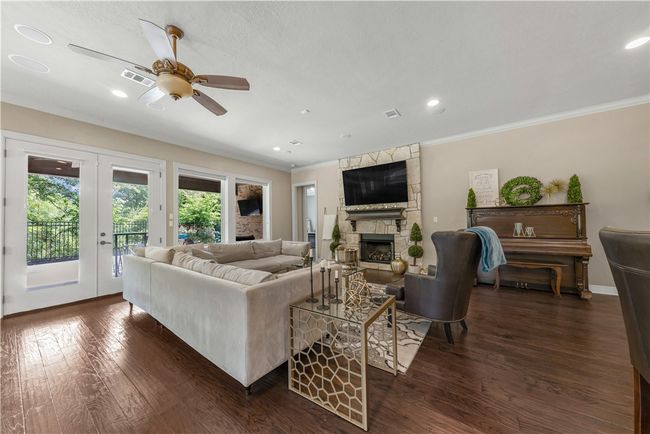 Living room with ornamental molding, healthy amount of natural light, a fireplace, dark wood-style flooring, and recessed lighting | Image 10
