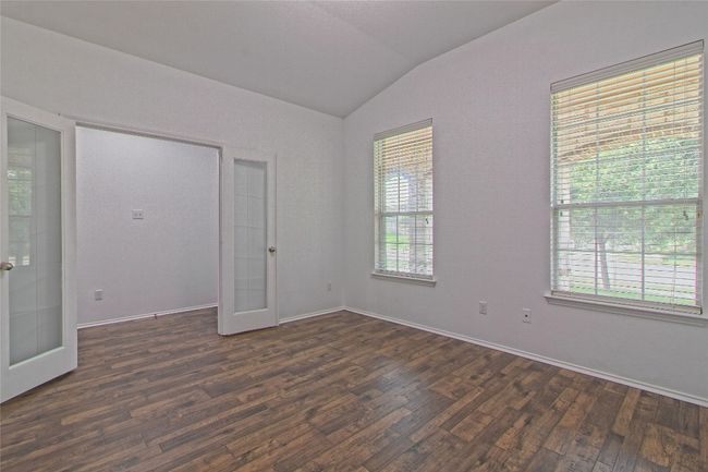 Spare room with french doors, vaulted ceiling, dark wood finished floors, and healthy amount of natural light | Image 5
