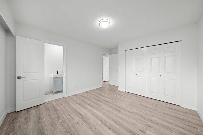 Unfurnished bedroom with light wood finished floors, baseboards, a closet, and ensuite bathroom | Image 11