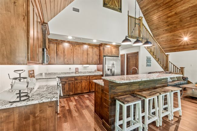 Second homewith full kitchen with range, microwave, dishwasher, refrigerator and island seating. | Image 6