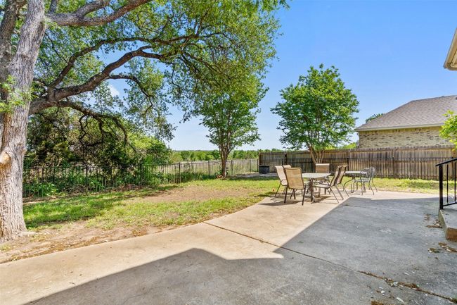 The backyard features a spacious patio perfect for summer BBQs. | Image 36