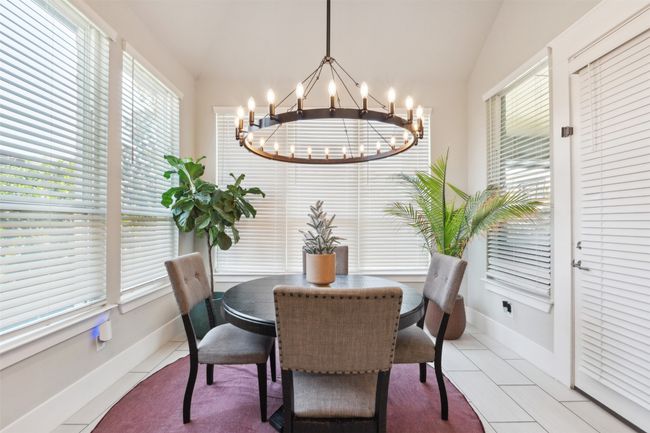 Tiled dining room with healthy amount of natural light, a chandelier, and lofted ceiling | Image 15