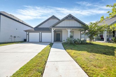 View of front of house featuring a garage, covered porch, and a front yard | Image 2