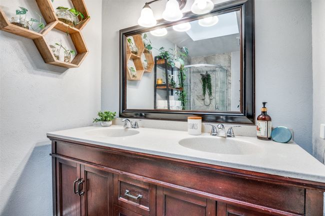 Bathroom featuring double vanity, a shower stall, and a textured wall | Image 16