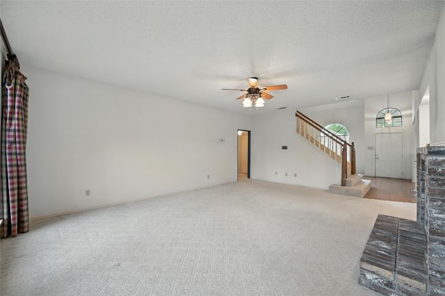 Unfurnished living room featuring stairs, a ceiling fan, and carpet floors | Image 13