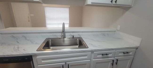 Kitchen featuring stainless steel dishwasher and white cabinets | Image 9