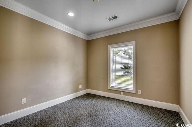 Unfurnished room featuring crown molding, dark colored carpet, baseboards, and recessed lighting | Image 8