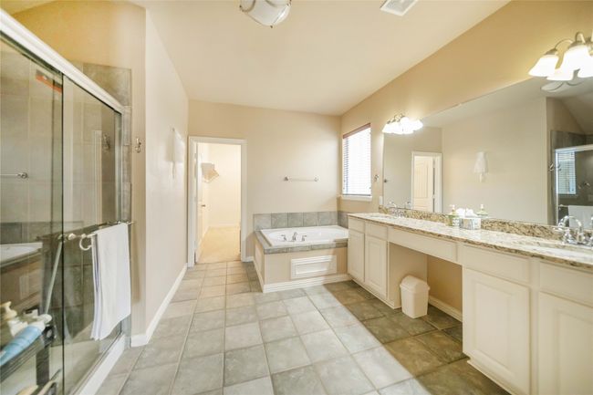 Full bath featuring double vanity, a garden tub, a shower stall, and tile patterned flooring | Image 22