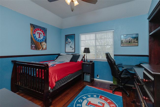 Bedroom with baseboards, wood finished floors, and a ceiling fan | Image 30