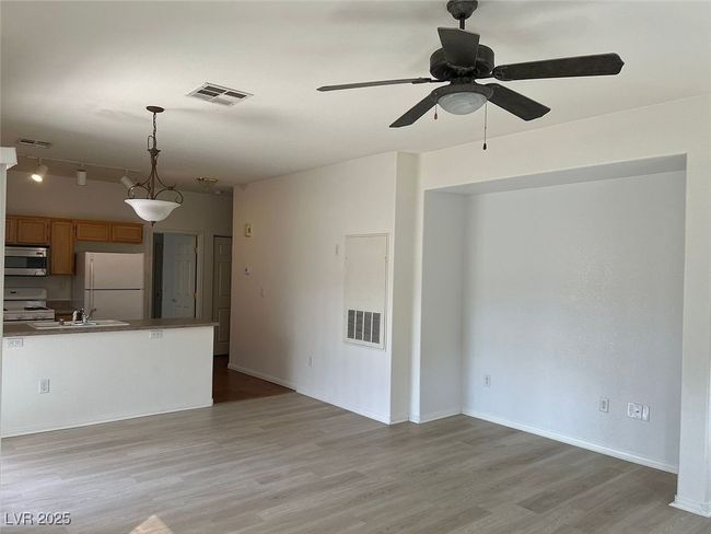 Unfurnished living room featuring light wood-style flooring and ceiling fan | Image 9