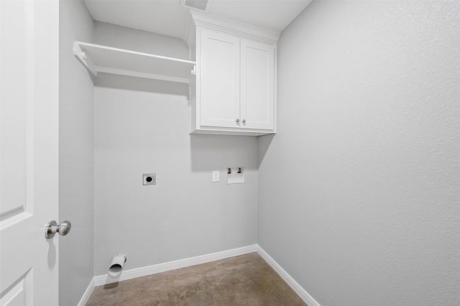 Clothes washing area with cabinet space, electric dryer hookup, hookup for a washing machine, visible vents, and baseboards | Image 6