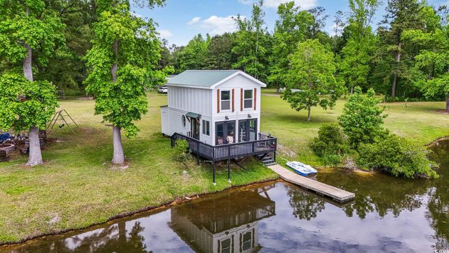 Rear view of house featuring a lawn, view of scattered trees, and metal roof | Image 26