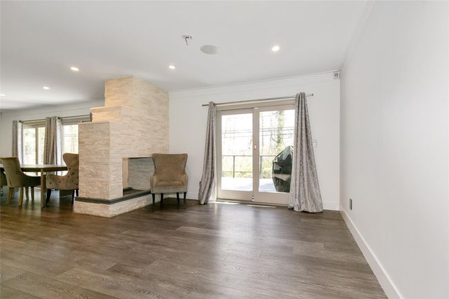 Sitting room with dark wood-type flooring, recessed lighting, ornamental molding, and baseboards | Image 6