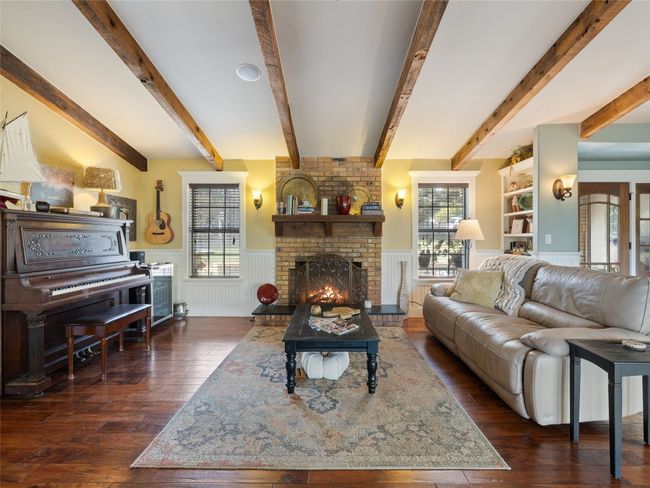 Sitting area in the great room features a cozy fireplace. | Image 23