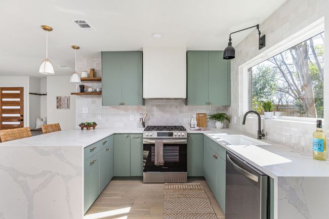 Kitchen featuring stainless steel appliances, a peninsula, backsplash, green cabinetry, and recessed lighting | Image 16