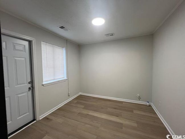 Empty room with visible vents, baseboards, crown molding, and wood finished floors | Image 10