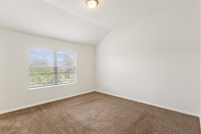 Carpeted spare room featuring lofted ceiling and baseboards | Image 17