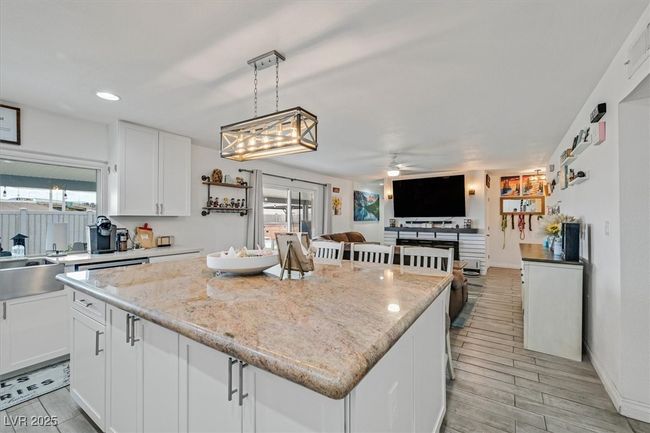 Kitchen with plenty of natural light, ceiling fan, a center island, and white cabinetry | Image 6