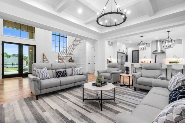 Living area featuring a chandelier, light wood-type flooring, beam ceiling, stairs, and recessed lighting | Image 7
