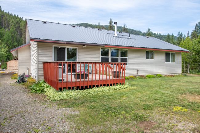 Rear view of property featuring a metal roof, a lawn, and a deck | Image 11