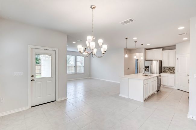 Kitchen featuring stainless steel appliances, decorative backsplash, a chandelier, recessed lighting, and light countertops | Image 15