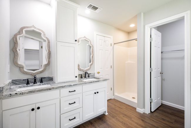 Bathroom with wood finished floors, a stall shower, double vanity, and recessed lighting | Image 14