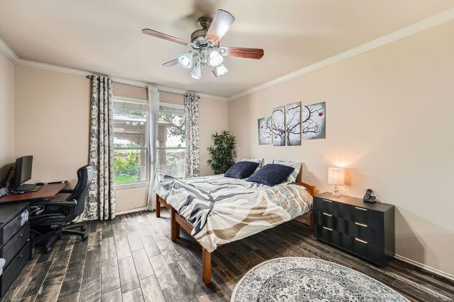 Bedroom with crown molding, a desk, dark wood-style floors, and a ceiling fan | Image 18
