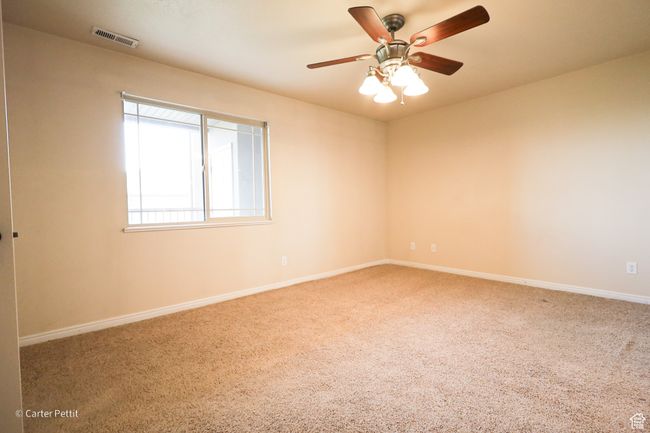 Carpeted spare room with baseboards and a ceiling fan | Image 18