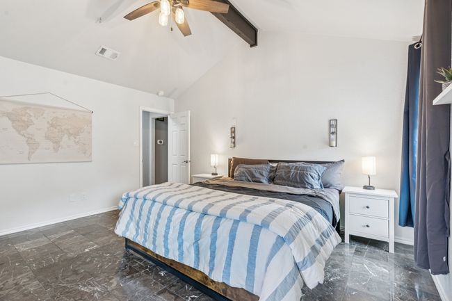 Primary bedroom with tile flooring, vaulted ceiling, and window overlooking the pool in the backyard! | Image 15