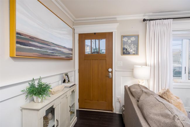 Entryway with a wainscoted wall, dark wood-style flooring, a decorative wall, and crown molding | Image 9