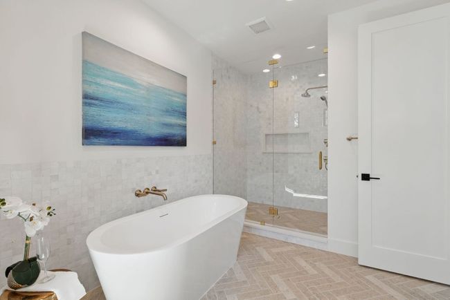 Bathroom with a soaking tub, a shower stall, tile walls, and recessed lighting | Image 15