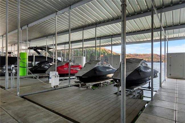 Dock area featuring a water view and boat lift | Image 64