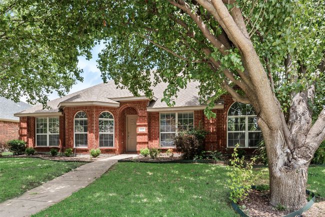 Traditional-style home featuring brick siding, roof with shingles, and a front lawn | Image 4