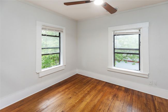Unfurnished room with ornamental molding, ceiling fan, hardwood / wood-style flooring, and baseboards | Image 22